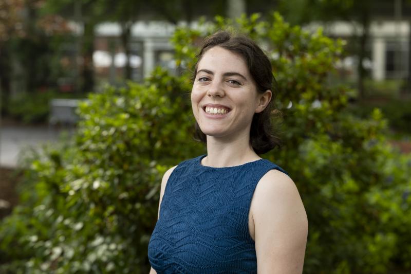 A woman in a blue shirt smiling.