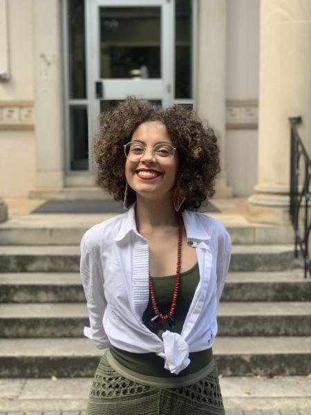 The image shows a curly hair woman smiling.