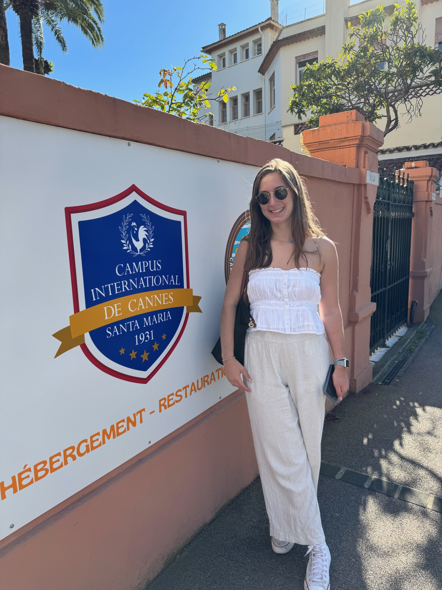 Emily in front of campus entrance sign