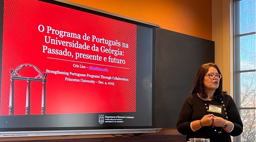 Dr. Lira stands in front of her presentation slide. 