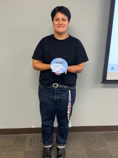 Mariana holds a blue painting.