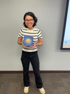 Késsia Shingu smiling and holding a paint. 