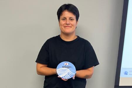 Mariana holds a blue painting.