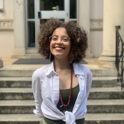 The image shows a curly hair woman smiling.