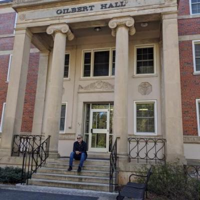 man standing in front of the Gilbert Hall